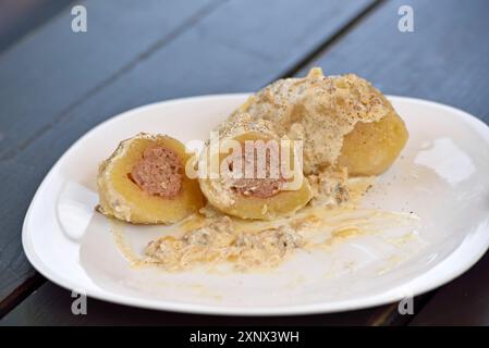 Cepelinai, piatto nazionale, patate ripiene di carne macinata, servito al ristorante-panetteria Romnesa a Strigailiskis, distretto di Ignalina, Lituania Foto Stock