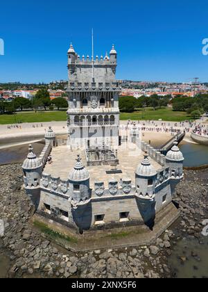 Una torre vicino a una città sulla riva con acqua blu, cielo e visitatori turistici, vista aerea, Torre de Belem, sito Patrimonio dell'Umanità, Belém, Betlemme Foto Stock