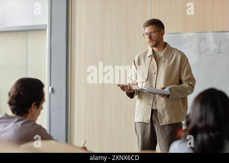Corso completo medio di professori maschi adulti che insegnano agli studenti che tengono lezioni presso la sala dell'università, spazio copia Foto Stock