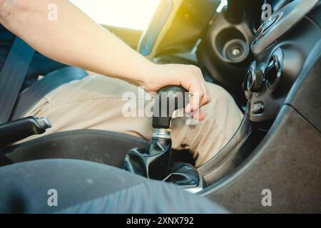 Primo piano della mano del conducente sulla leva del cambio di un'auto, mano del conducente che afferra la leva del cambio dell'auto, primo piano delle mani che accelerano la leva del cambio Foto Stock