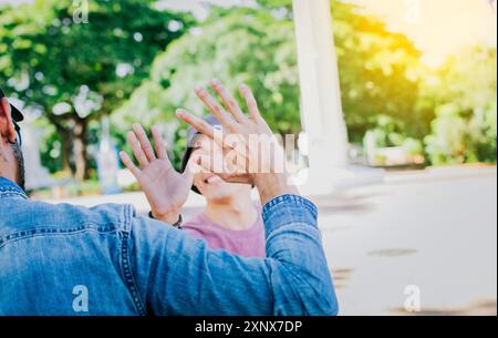 Primo piano di persone sorridenti che stringono la mano all'aperto. Vista posteriore di due amici sorridenti che stringono la mano sulla strada Foto Stock