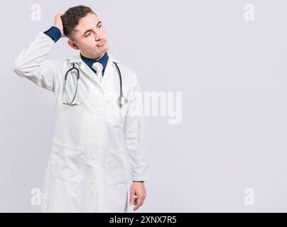 Medico confuso e premuroso isolato. Medico incerto che gratta la testa isolata. Medico premuroso che gratta la testa Foto Stock