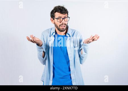 Uomo che sparge le palme, si sente indifeso e incerto isolato. Un giovane che si spalanca le mani sconcertate Foto Stock