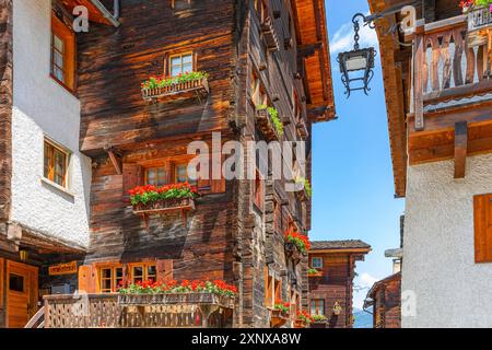 Vecchie case con fioriere davanti a finestre e balconi nel centro storico del paese, Grimentz, Val d'Anniviers, Alpi Vallese, Canton Vallese Foto Stock