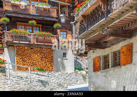 Vecchie case in legno con fioriere davanti a finestre e balconi nel centro storico del paese, Grimentz, Val d'Anniviers, Alpi Vallese, Cantone Foto Stock