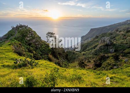 Atmosfera serale, verde paesaggio costiero su una ripida scogliera, mare e costa, punto panoramico Miradouro da Raposeira, Paul do Mar, Madeira, Portogallo Foto Stock