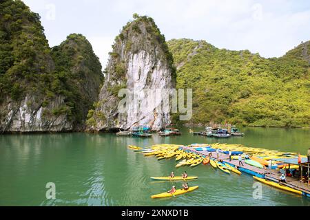 Kayak gialli in un molo e rocce carsiche nella baia di LAN ha, nella baia di ha Long, in Vietnam Foto Stock