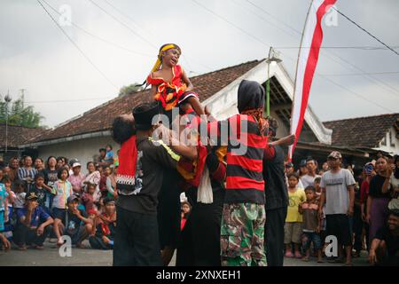 Un ragazzo sul corpo di una ballerina di barong cade in trance nel villaggio di Sukomoro, Puncu Kediri, Giava orientale, Indonesia. Foto Stock