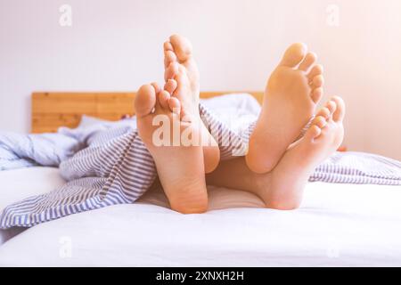 Primo piano una coppia scoperto piedi dormendo in letto, mattina Foto Stock