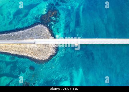 Veduta aerea del ponte che collega le isole che attraversano il fiordo con acque turchesi artiche, Flakstadburene, Fredvang, isole Lofoten, Norvegia, Scandinavia Foto Stock