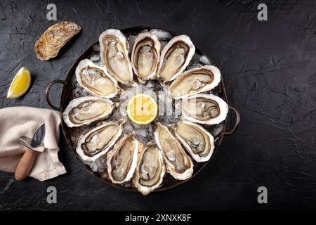 Ostriche con limoni, scattate dall'alto con un posto per il testo su uno sfondo di ardesia nera Foto Stock