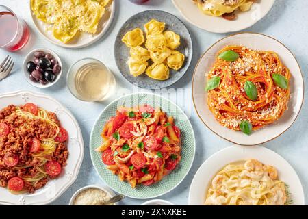 Pasta, molte varietà diverse, colpo piatto sospeso. Cibo e bevande italiane, scattate dall'alto. Spaghetti in salsa di pomodoro, pasta di pollo Foto Stock