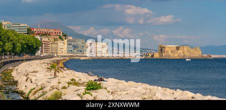 Vista dell'architettura color pastello, dei ristoranti e del Castello di Ovo sul lungomare di via Partenope e del Vesuvio, Napoli, Campania, Italia, copia Europa Foto Stock