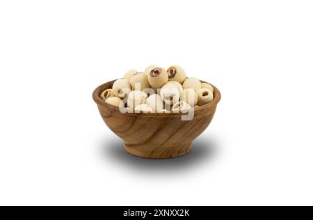 Semi di loto essiccati in una ciotola di legno su sfondo bianco con percorso di ritaglio. Oggigiorno i semi di loto diventano cibo sano popolare e ha altamente benefico Foto Stock