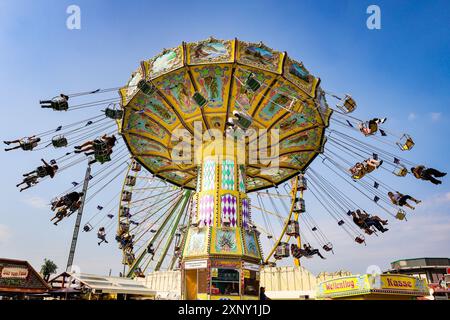 Herne, NRW, Germania. 2 agosto 2024. Un tradizionale carosello di chairoplane al sole. Cranger Kirmes, la seconda fiera più grande della Germania (dopo l'Oktoberfest di Monaco), apre oggi. La vivace fiera ha una lunga tradizione che risale al XV secolo, dove un mercato di cavalli e successivamente intrattenitori medievali, legnavano la folla. Cranger Kirmes attrae circa 4 milioni di visitatori ogni anno in un sito dedicato lungo il canale Reno-Herne. Crediti: Imageplotter/Alamy Live News Foto Stock