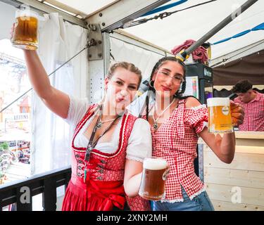 Herne, NRW, Germania. 2 agosto 2024. Due cameriere servono con un sorriso. Cranger Kirmes, la seconda fiera più grande della Germania (dopo l'Oktoberfest di Monaco), si apre con la tradizionale spillatura del barile, effettuata dal sindaco Frank Dudda, dal vice PM dell'NRW Mona Neubaur e da altri, oltre all'intrattenimento della cantante tedesca Vanessa mai. La vivace fiera ha una lunga tradizione che risale al XV secolo, dove un mercato di cavalli e successivamente intrattenitori medievali, legnavano la folla. Cranger Kirmes attrae circa 4 milioni di visitatori ogni anno in un sito dedicato lungo il canale Reno-Herne. Foto Stock