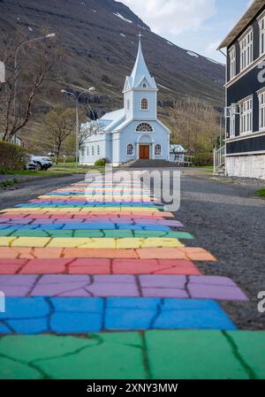 Chiesa con Rainbow Road a Seydisfjordur, Islanda, vista dall'angolo basso, ripresa verticale Foto Stock