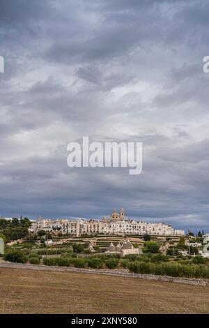 Vista dello skyline di Locortondo in Puglia da un campo di ulivo Foto Stock