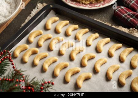 Preparazione di mezzaluna di vaniglia fatte in casa o Kipferl - biscotti di Natale tradizionali. Pasta cruda prima della cottura. Foto Stock