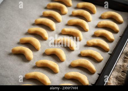 Pasta dolce cruda su teglia da forno - preparazione di mezzaluna di vaniglia fatte in casa o Kipferl, biscotti tradizionali di Natale Foto Stock