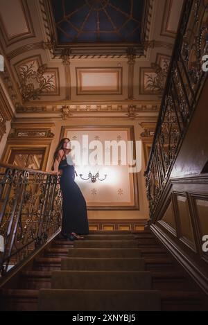 Donna elegantemente vestita sulla Grand Staircase in lussuosi interni dell'hotel Foto Stock