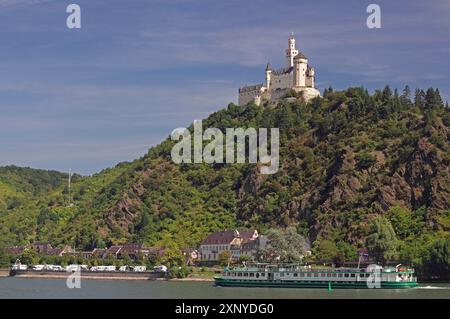 Un castello su una collina verde, sulla riva di un fiume, con una nave in primo piano, Medioevo, Marksburg, Reno, Renania-Palatinato, Germania Foto Stock