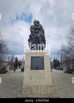 CHISINAU, MOLDAVIA, 20 marzo 2024 Monumento in memoria delle vittime della deportazione del regime comunista accanto all'edificio della stazione ferroviaria Foto Stock
