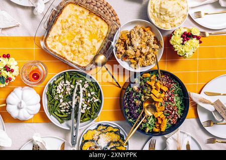Un tavolo del Ringraziamento splendidamente organizzato con vari piatti tradizionali colorati come insalata fresca, fagiolini e purè di patate Foto Stock