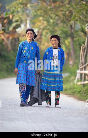 Due donne della minoranza hmong in abiti di tutti i giorni stanno su una strada e guardano nella telecamera, Du gia, provincia di ha Giang, Vietnam Foto Stock