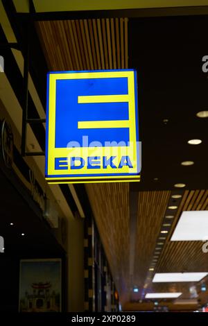 Pubblicità illuminata dello sportello Edeka nel centro di Berlino in serata Foto Stock