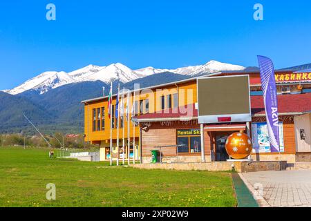 Bulgaria, Bansko, 5 maggio 2020: Grande ballo giallo di Capodanno, Bansko ti ama vicino alla stazione degli impianti di risalita della funivia e alle montagne innevate Foto Stock