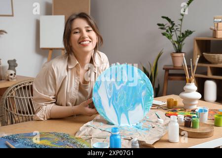 Artista femminile che crea pittura d'arte fluida in laboratorio Foto Stock