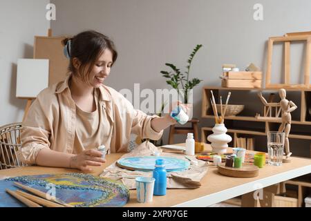 Artista femminile che crea pittura d'arte fluida in laboratorio Foto Stock