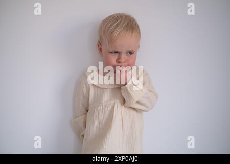 Divertente bambina che sembra sospetta e curiosa. Foto Stock