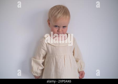 Divertente bambina che sembra sospetta e curiosa. Foto Stock