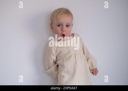 Divertente bambina che sembra sospetta e curiosa. Foto Stock