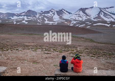 Due bambini che osservano la cima di Ighil M'Goun, 4, 071 metri, catena montuosa dell'Atlante, marocco Foto Stock