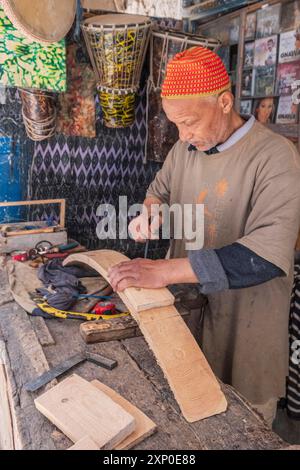 Artigiano liutaio che fa uno strumento musicale, Essaouira, marocco Foto Stock