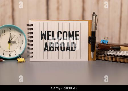 LAVORARE ALL'ESTERO testo scritto su carta gialla con quaderno Foto Stock