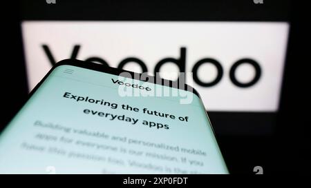 Stoccarda, Germania, 03-28-2022: Telefono cellulare con pagina web della società francese di videogiochi Voodoo SAS sullo schermo davanti al logo aziendale. Concentrati su Foto Stock