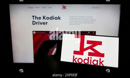 Stoccarda, Germania, 03-12-2022: Persona che detiene un cellulare con il logo della società di logistica statunitense Kodiak Robotics Inc. Sullo schermo davanti all'azienda Foto Stock