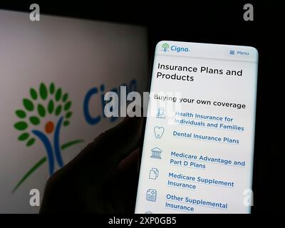 Stoccarda, Germania, 03-01-2022: Persona che detiene cellulare con sito web della compagnia di assicurazione sanitaria americana Cigna Corporation sullo schermo con logo. Concentrati su Foto Stock