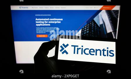 Stoccarda, Germania, 05-08-2022: Persona che detiene il cellulare con il logo della società austriaca di software Tricentis GmbH sullo schermo davanti all'azienda Foto Stock