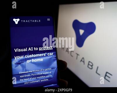 Stoccarda, Germania, 05-08-2022: Persona che detiene un cellulare con sito web della società di intelligenza artificiale Tractable Ltd. Su schermo con logo. Concentrati su Foto Stock