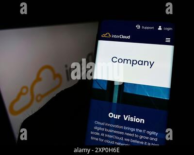 Stoccarda, Germania, 02-20-2022: Persona che detiene un cellulare con sito web della società francese di soluzioni di rete InterCloud SAS su schermo con logo. Concentrati Foto Stock