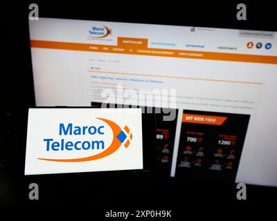 Stoccarda, Germania, 02-13-2022: Persona che detiene il cellulare con il logo della società di telecomunicazioni Maroc Telecom (IAM) sullo schermo davanti alla pagina web. Foto Stock