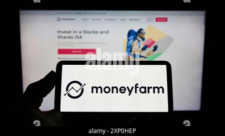 Stoccarda, Germania, 02-11-2022: Persona che detiene il cellulare con il logo della società britannica di consulenza sugli investimenti Moneyfarm sullo schermo davanti alla pagina web. Foto Stock