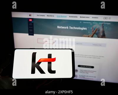 Stoccarda, Germania, 02-11-2022: Persona che detiene un cellulare con il logo della società di telecomunicazioni KT Corporation sullo schermo davanti al web aziendale Foto Stock