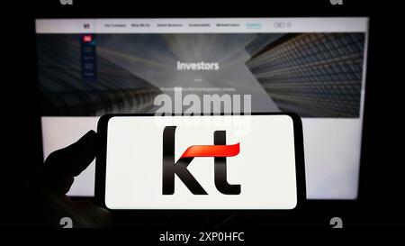 Stoccarda, Germania, 02-11-2022: Persona che detiene un telefono cellulare con il logo della società di telecomunicazioni KT Corporation sullo schermo davanti all'azienda Foto Stock