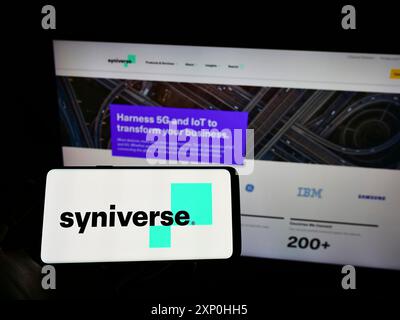 Stoccarda, Germania, 02-11-2022: Persona che detiene il cellulare con il logo della società di telecomunicazioni americana Syniverse Technologies LLC sullo schermo di fronte Foto Stock